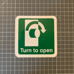 Clockwise turn to open sign, 100x100mm on self adhesive vinyl