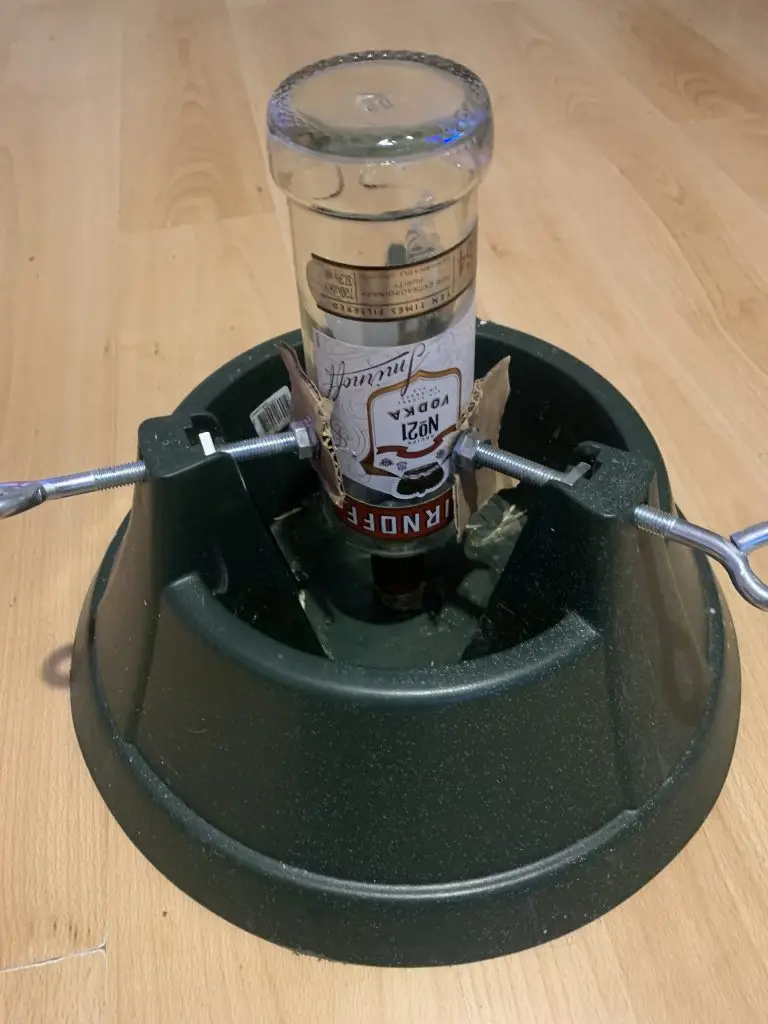 Christmas tree stand used as a bottle clamp.