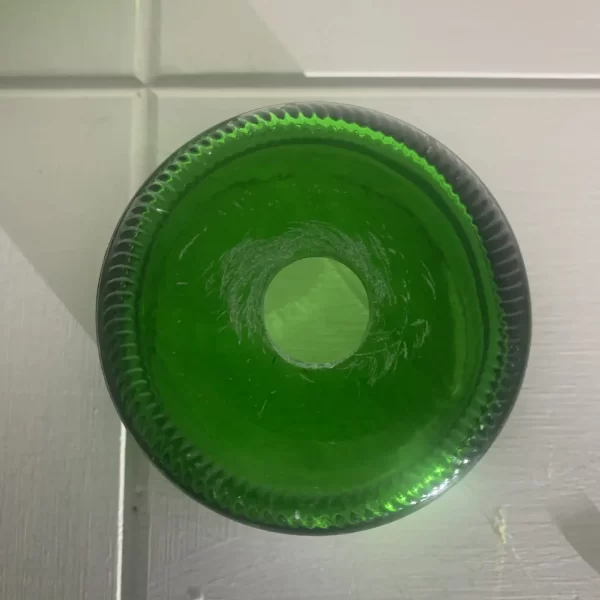 A hole drilled in the base of an Appletiser bottle.