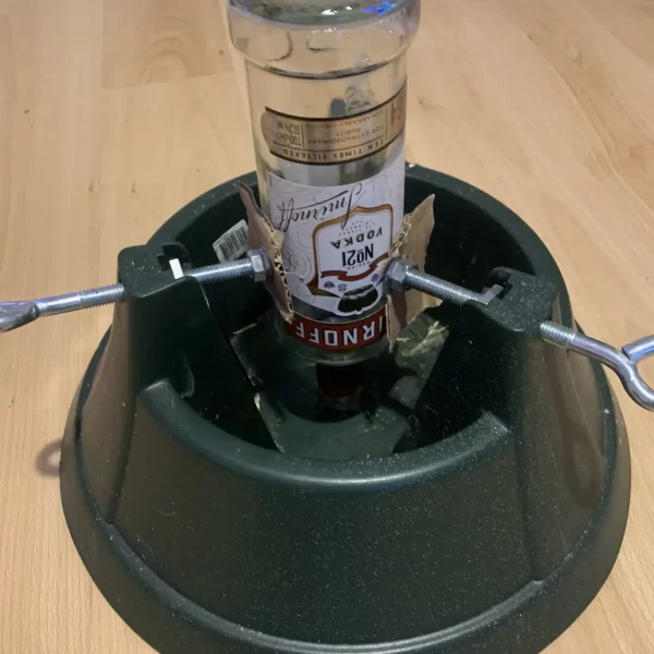 Christmas tree stand used as a bottle clamp.